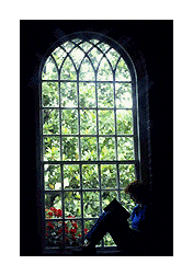 person reading next to a large window